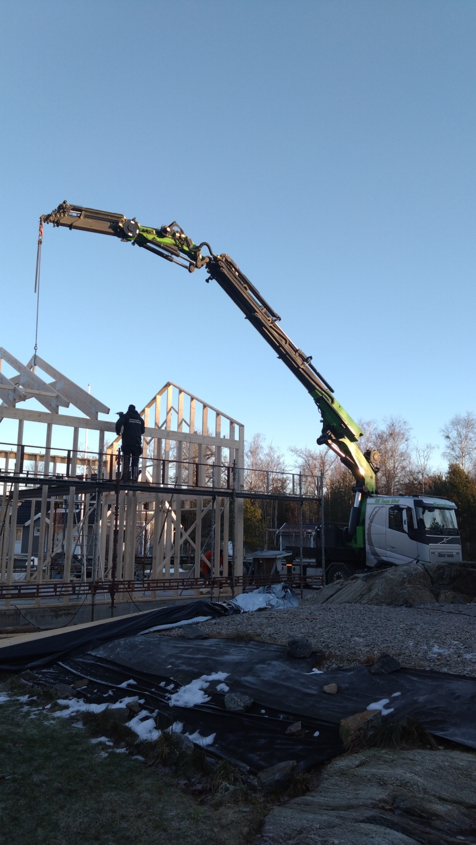 Kranbil lyfter på byggnadsmaterial.